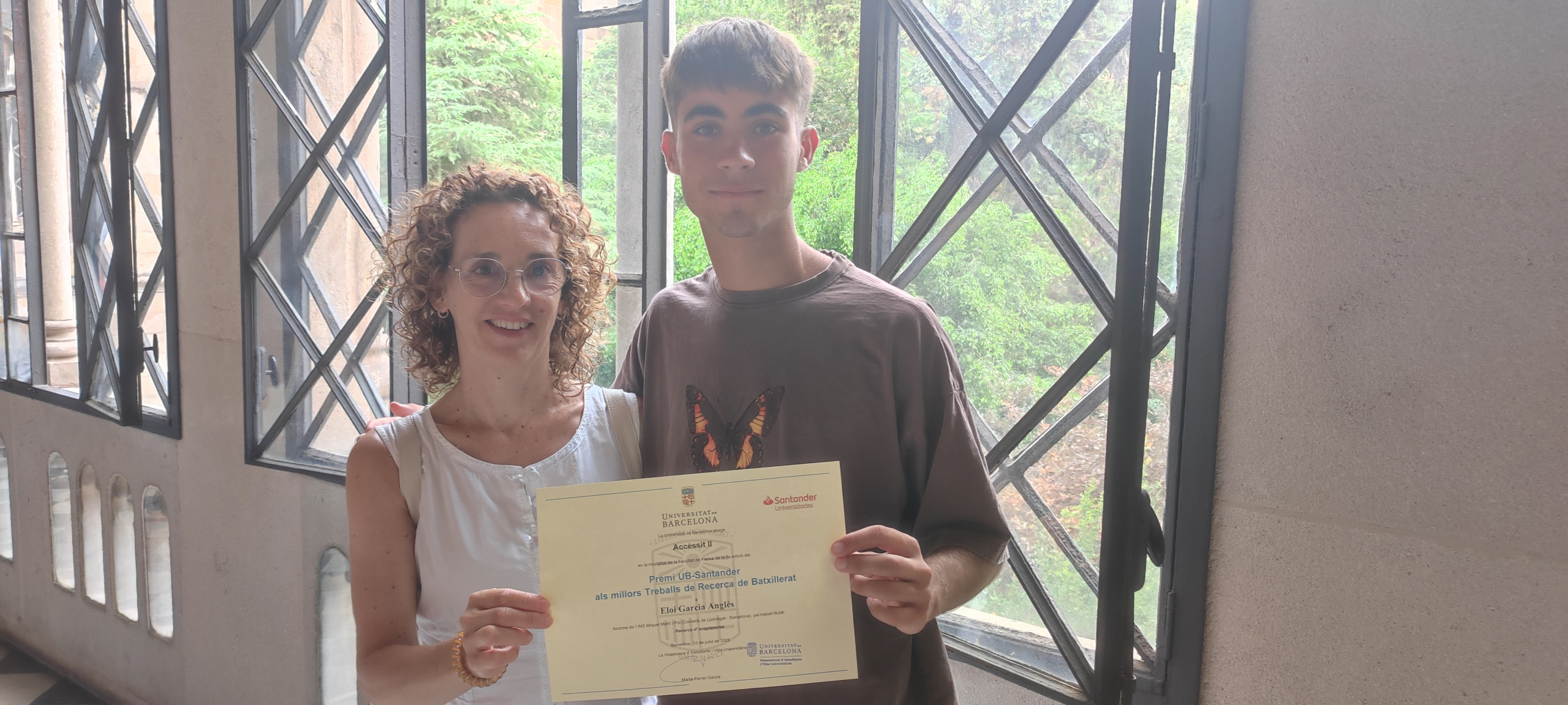 El estudiante Eloi García, estudiante de bachillerato del Institut Miquel Martí i Pol, y su tutora del trabajo de investigación "Recerca d'exoplanetes" con el premio recibido.